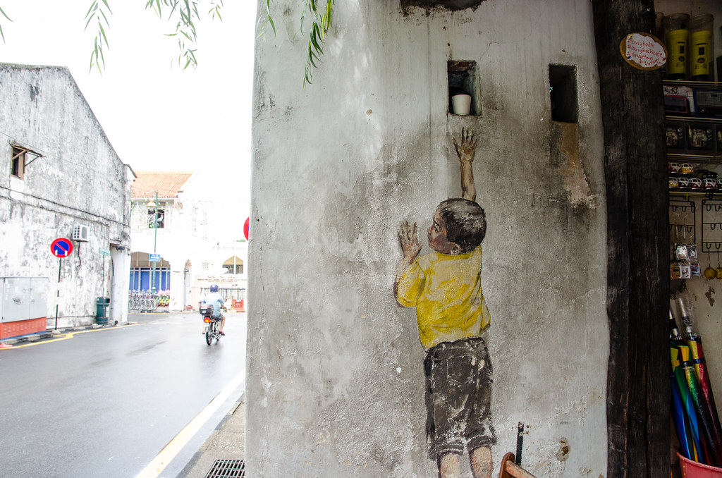Famous Penang mural arts - The boy on chair, trying to reach something.