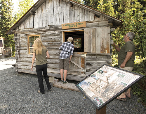 Visitors look at the Lindgren Cabin on display at K'Beq' Cultural Site in Cooper Landing.